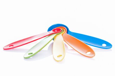 colorful measuring spoons isolated on whiteの写真素材