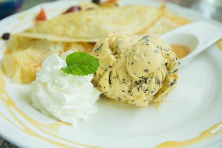 Vanilla ice cream, chocolate and whipped cream decorated by mint leavesの写真素材