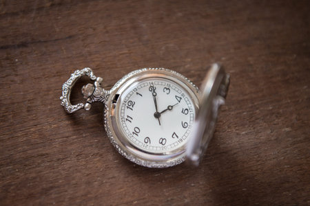 old pocket watch on wood background (vintage filter effect)