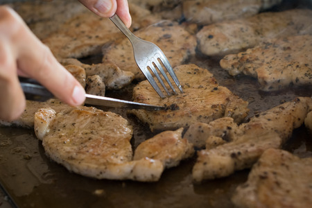 roasting meat with oil or butter in saucepan in interior of modern restaurant kitchenの写真素材