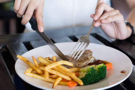 Woman eating steak in restaurant