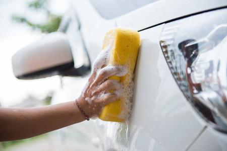 women washing car with yellow spongeの写真素材