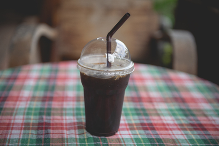 Black coffee in a plastic glass with ice in a beverage outlet.の写真素材