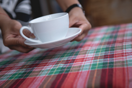 Employees in coffee shops are sending coffee mugs to customers.の写真素材