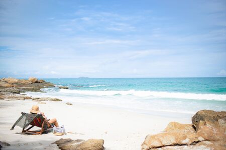 Summer beach vacation concept, woman with hat  and beverages relaxing on chair beach at Koh samet, rayong, Thailandの写真素材