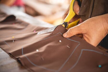 Woman's hand sewing fabric with sewing equipmentsの写真素材