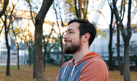 Happy young man enjoying autumn season at a beautiful park in Buenos Aires
