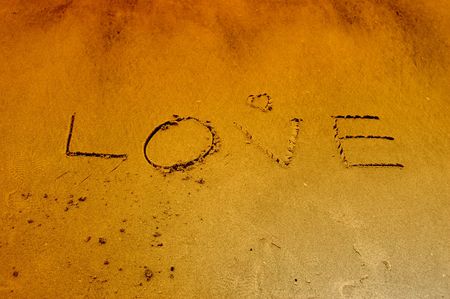 The word love written on the sand at the beachの写真素材