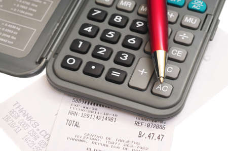 Macro shot of a calculator and a red pen over some receipst on whiteの写真素材