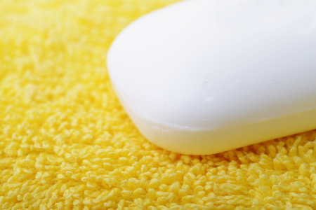 Close up of a white soap bar over a yellow towelの写真素材