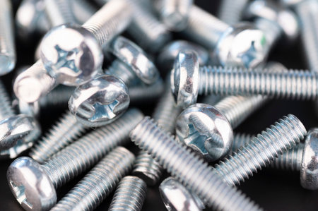 Macro shot of a bunch of silver bolts on a black backgroundの写真素材