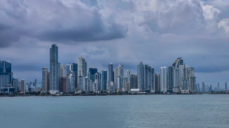 A panoramic view of Panama City, Panama, showcasing its iconic skyline along the waterfront. Modern skyscrapers dominate the scene, rising dramatically against a backdrop of moody clouds.の写真素材