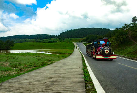 Cars on the road on the background of green fields and blue skyの写真素材