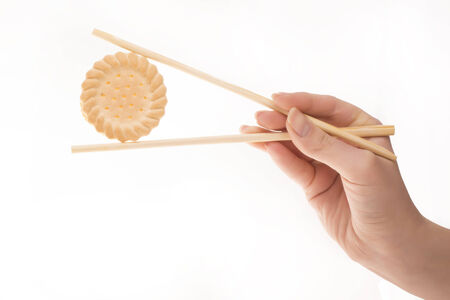 Hand using chopsticks on Sushi biscuitsの写真素材