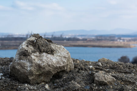 Old stone against the background of lake during the dayの写真素材