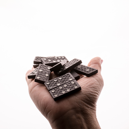 Dominoes in hand on a white backgroundの写真素材