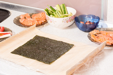 Cooking sushi at home with nori, salmon, avocado, rice and cucumber.の写真素材