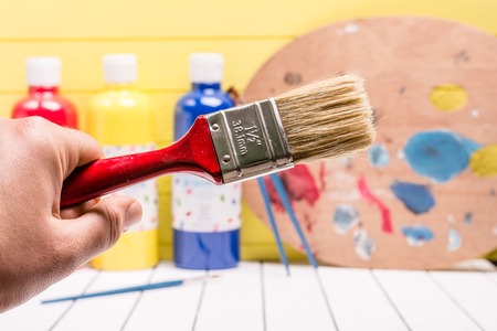 Large paintbrush on a white and yellow backgroundの写真素材