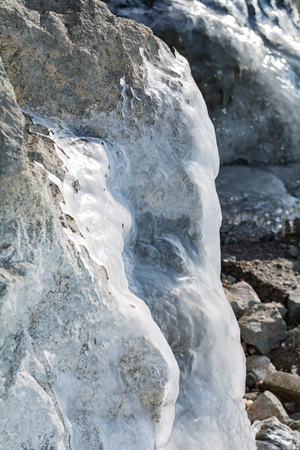 Frozen rocks with ice in the winter pondの写真素材