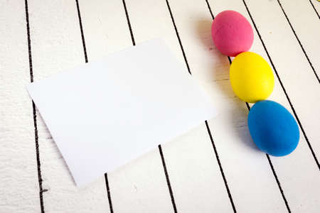 Colorful Easter eggs and empty white sheet of wood backgroundの写真素材