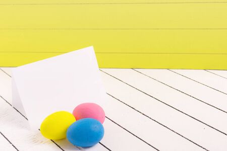Colorful Easter eggs and empty white sheet of wood backgroundの写真素材