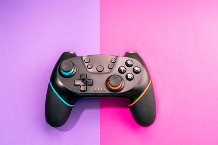 Video game competition. Game concept. black joystick on pastel purple and pink background.