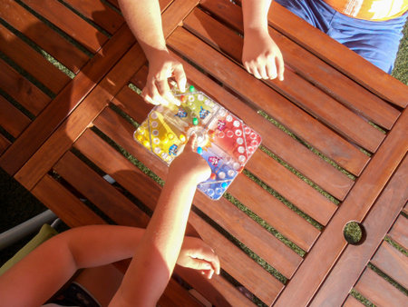 girl playing a board game called Connect Four, Four in a Row or Four in a Line, with round pieces in...