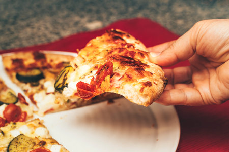 chicken and cherry tomato and vegetable pizza with sourdough and crispy golden crust on a white...