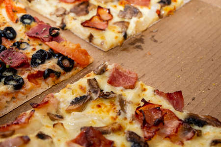 three slices of different types of pizza on a cardboard box.の写真素材