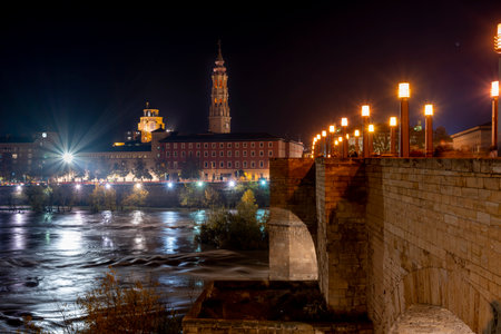 view from the stone bridge with the ebro river as it passes through the city of zaragoza with the tower of La Seo in the background. Long exposure image.の写真素材