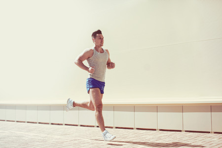 Fitness, workout, sport, lifestyle concept - man running in the cityの写真素材