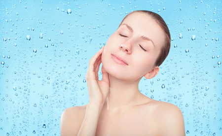 Beauty woman, skin care and freshness background with splash water drops, female portrait enjoying clean skinの写真素材
