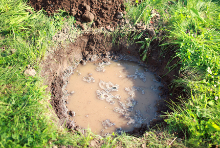 hole in the ground, soil and waterの写真素材