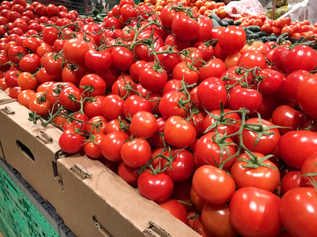 Many red tomatoes in the boxes supermarket close-upの写真素材