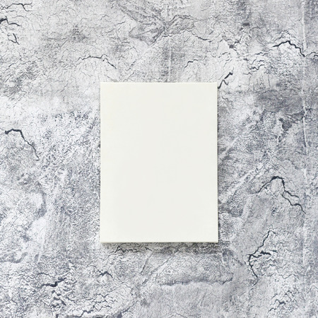 photo frame or board hanging on a decorated gray wall with cracks close-upの写真素材
