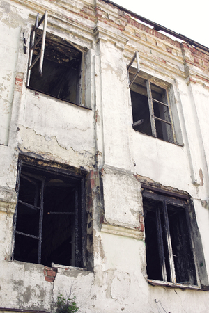 Old burnt house with charred wooden windows, bottom viewの写真素材