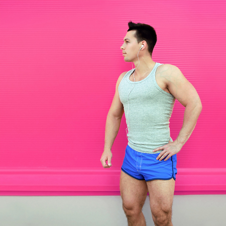 Sportsman stands in shorts on colorful pink wall background. Fitness, sport conceptの写真素材
