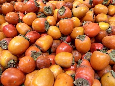 Many fresh fruits persimmons in supermarket, food backgroundの写真素材