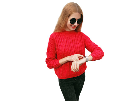 young smiling woman looking at smart watch using voice assistant or takes calling isolated on white backgroundの写真素材