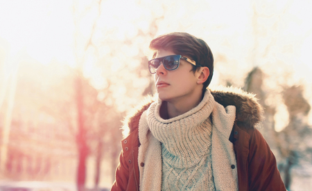 Fashion portrait man in sunglasses walking in sunny evening cityの写真素材