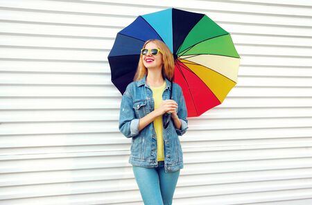Portrait happy smiling woman with colorful umbrella, dreams looking away on white backgroundの写真素材