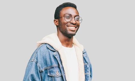 Portrait of happy smiling african man looking away wearing an eyeglasses on a gray background