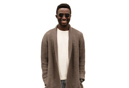 Portrait of stylish smiling young african man wearing knitted cardigan isolated on white backgroundの写真素材