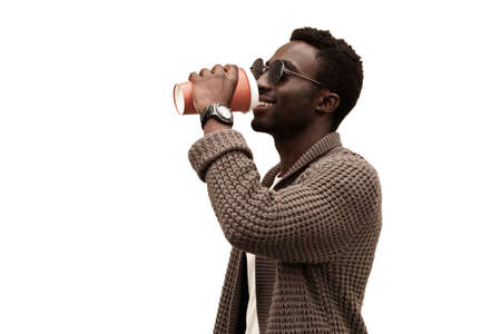 Portrait of happy young african man drinking coffee isolated on white backgroundの写真素材