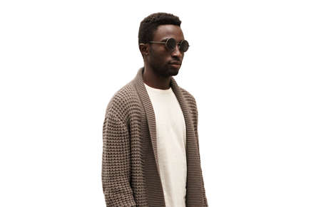 Fashionable portrait of stylish african man model looking away wearing knitted cardigan isolated on white backgroundの写真素材