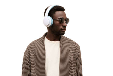 Portrait of african man in wireless headphones listening to music looking away isolated on white backgroundの写真素材