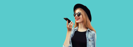 Portrait of happy smiling young woman with smartphone using voice command recorder, assistant or...