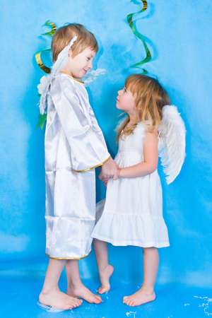 Beautiful little angels isolated over blue backgroundの写真素材