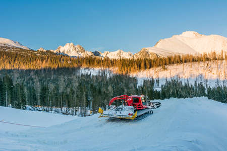 Snowcat while working with the mountain ridge in the backgroundの写真素材