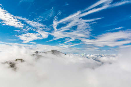 Above the clouds peaks on the horizonの写真素材